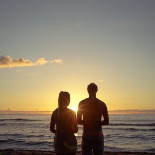 Couple profitant d’un coucher de soleil lors d’un road trip