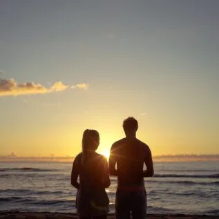 Couple profitant d’un coucher de soleil lors d’un road trip